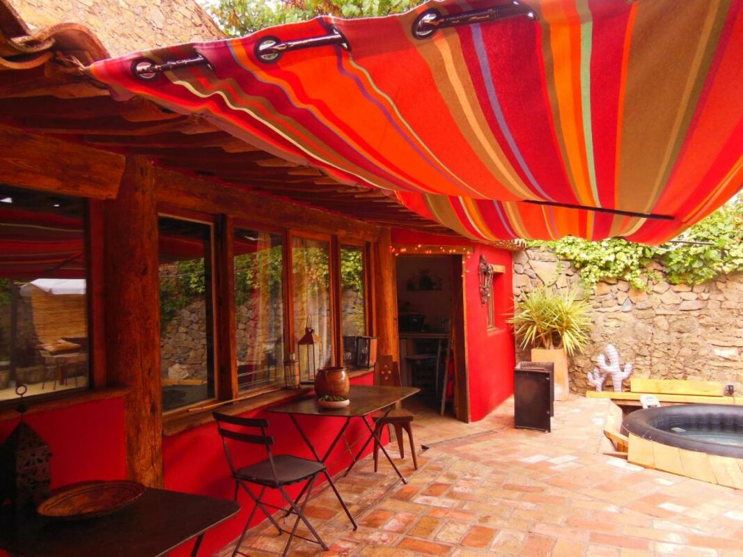 Terrasse extérieure ombragée avec une pergola colorée, espace détente en plein air à Côté Corbières.