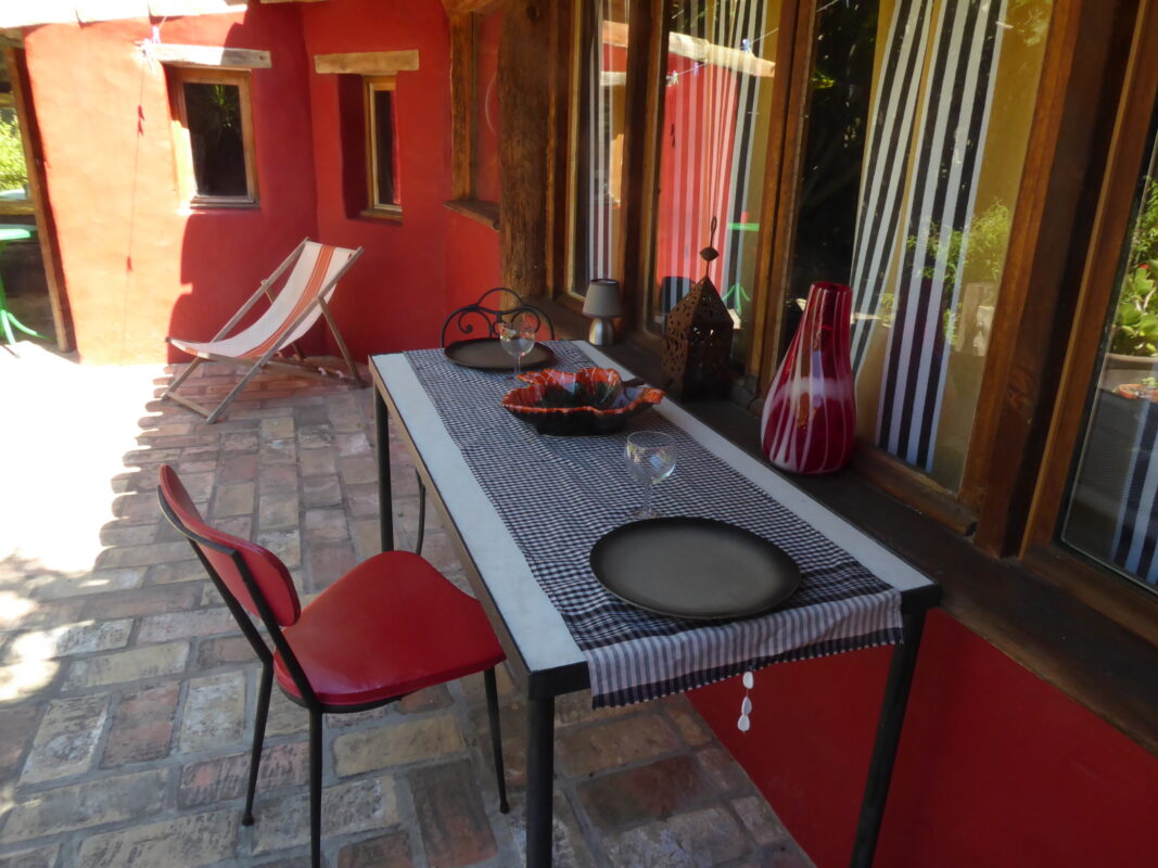 Terrasse extérieure avec table et chaises, décorée pour un repas en plein air, dans une maison d'hôtes à Villesèque-des-Corbières.