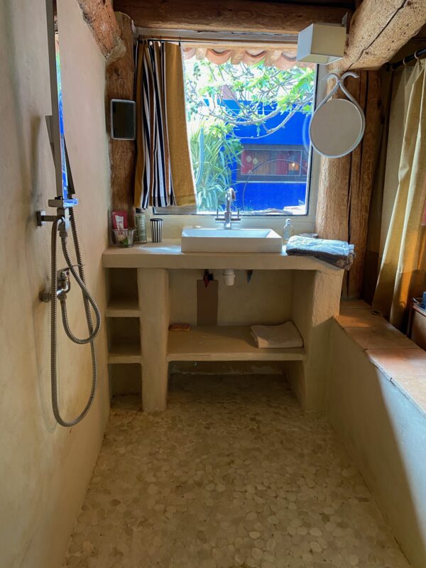 Salle de bain rustique avec douche à l'italienne et vue sur le jardin, dans la maison d'hôtes 'Maison dans un Jardin' à Villesèque-des-Corbières.